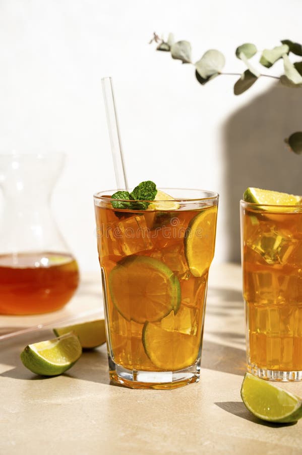 Iced Tea with Lemon, Fresh Mint Leaves and Ice in Tall Glasses with Sun ...