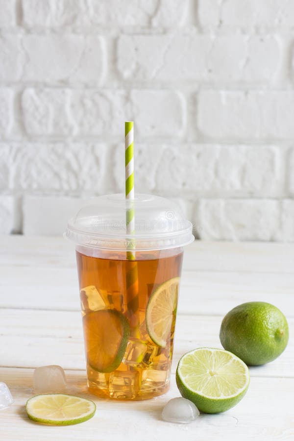 Premium Photo  Ice tea with slice of lemon in plastic cup on the wooden