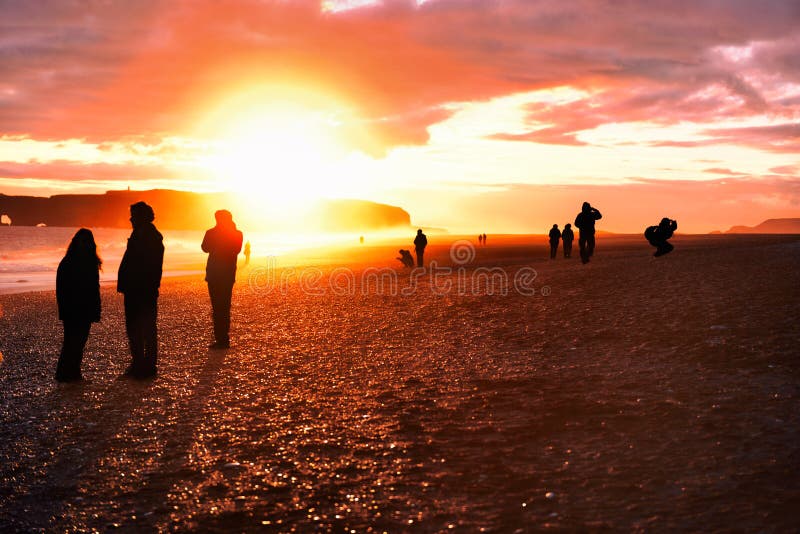 Iceland travel tourists walking on reynisfjara Black Sand Beach. Landscape photography tourists taking pictures, silhouettes of royalty free stock photos Iceland travel tourists walking on reynisfjara Black Sand Beach. Landscape photography tourists taking pictures, silhouettes of royalty free stock photos