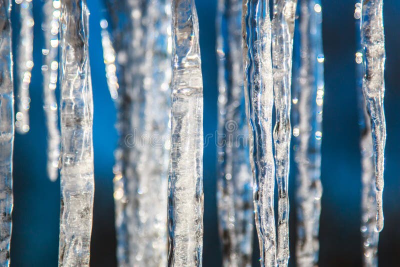 Icicles on a bright spring sun close, blurred abstract background