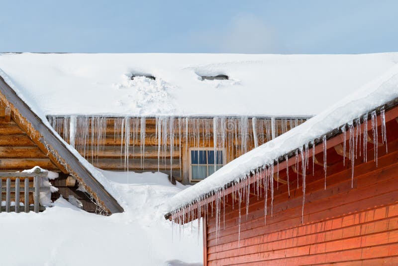 Icicles and snow on an old wooden cottage