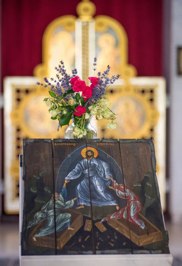 Icon of the Resurrection of Christ and a beautiful bouquet of flowers in a vase in a church