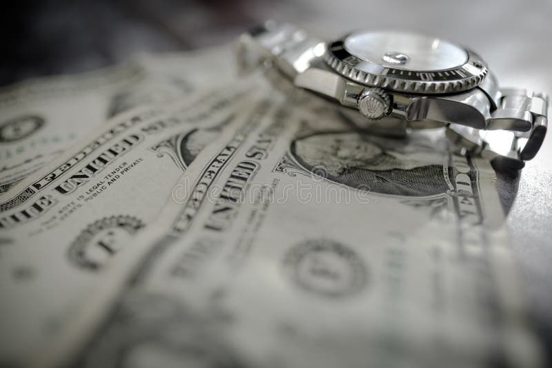 Iconic, swiss manufactured men`s automatic diving watch seen on used dollar bills. stock images Iconic, swiss manufactured men`s automatic diving watch seen on used dollar bills. stock images