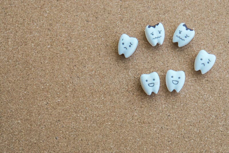 Icono de la historieta de los dientes de la salud e icono decaído en fondo de madera del corcho imágenes de archivo libres de regalías Icono de la historieta de los dientes de la salud e icono decaído en fondo de madera del corcho imágenes de archivo libres de regalías