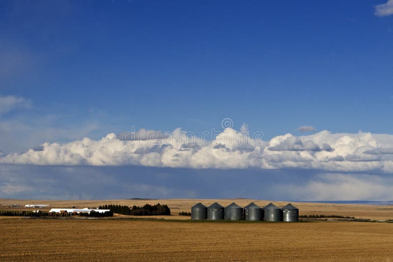 Idaho Silos and mega farm on the wide open plains with a threatning sky and inclement weather overhead and plowed fields in the foreground American West. Idaho Silos and mega farm on the wide open plains with a threatning sky and inclement weather overhead and plowed fields in the foreground American West