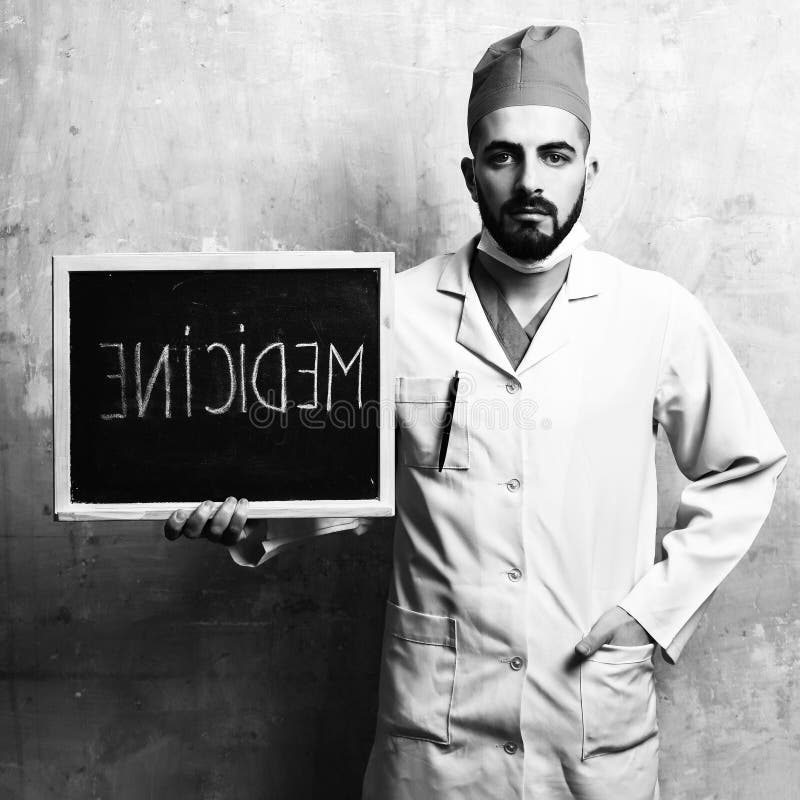 Idea di recupero e della medicina Medico con la barba tiene la piccola lavagna fotografie stock libere da diritti Idea di recupero e della medicina Medico con la barba tiene la piccola lavagna fotografie stock libere da diritti