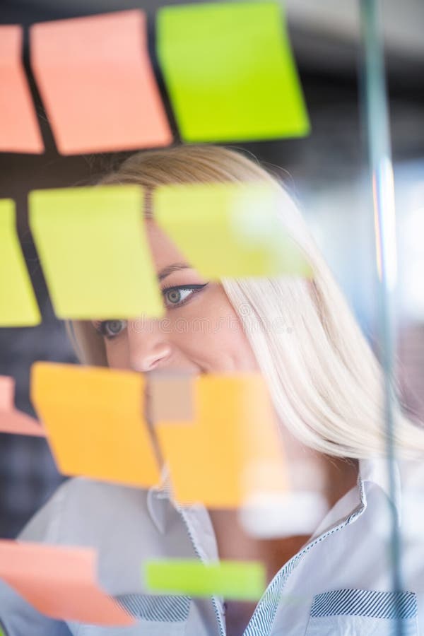 Ideale per il business, la startup, la pianificazione, la gestione e le persone - donne felici che scrivono su adesivi all'uffici immagini stock libere da diritti Ideale per il business, la startup, la pianificazione, la gestione e le persone - donne felici che scrivono su adesivi all'uffici immagini stock libere da diritti