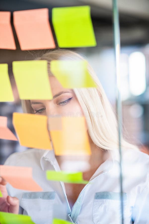 Ideale per il business, la startup, la pianificazione, la gestione e le persone - donne felici che scrivono su adesivi all'uffici fotografia stock Ideale per il business, la startup, la pianificazione, la gestione e le persone - donne felici che scrivono su adesivi all'uffici fotografia stock