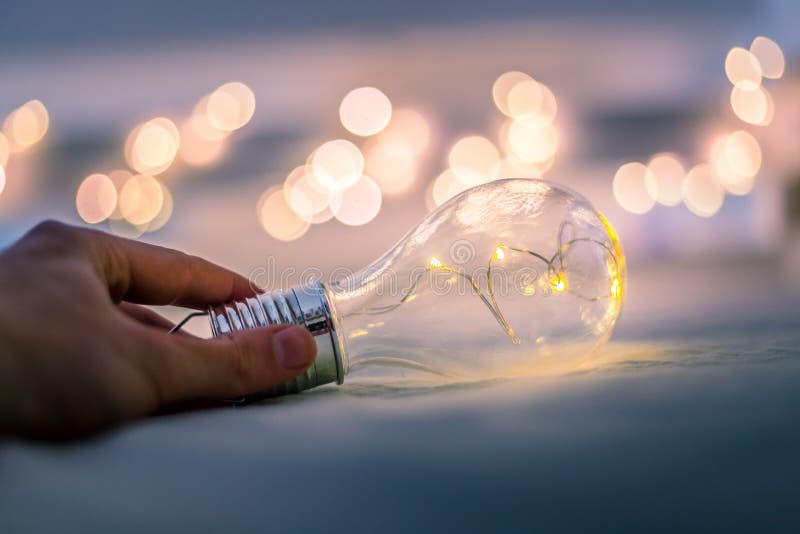 Ideas and Innovation Light Bulb with LEDs is Lying in the Bed, Hands