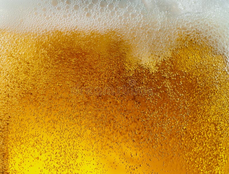 Ideia ascendente próxima de bolhas de flutuação na textura da cerveja clara foto de stock Ideia ascendente próxima de bolhas de flutuação na textura da cerveja clara foto de stock