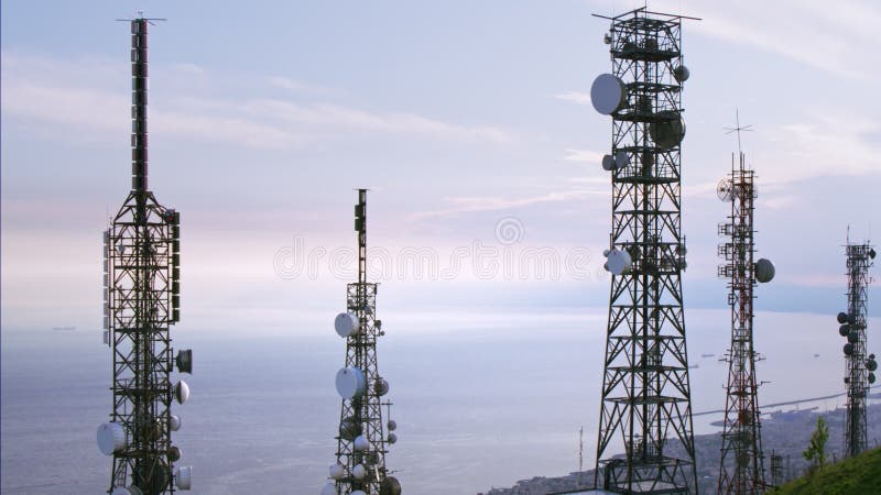 A ideia aérea das telecomunicações eleva-se antenas e arquitetura da cidade no fundo