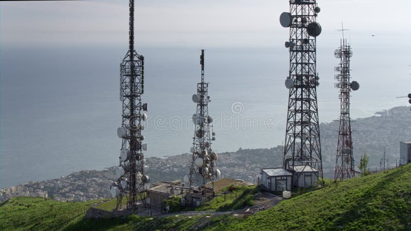 A ideia aérea das telecomunicações eleva-se antenas e arquitetura da cidade no fundo