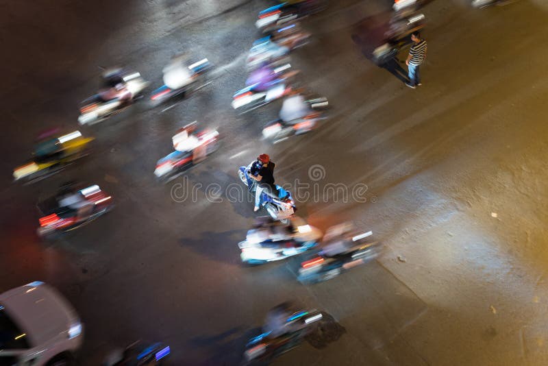Ideia aérea do tráfego de Hanoi com motocicleta imóvel e outros veículos borrados que correm ao redor Tráfego desarrumado em hora imagens de stock Ideia aérea do tráfego de Hanoi com motocicleta imóvel e outros veículos borrados que correm ao redor Tráfego desarrumado em hora imagens de stock