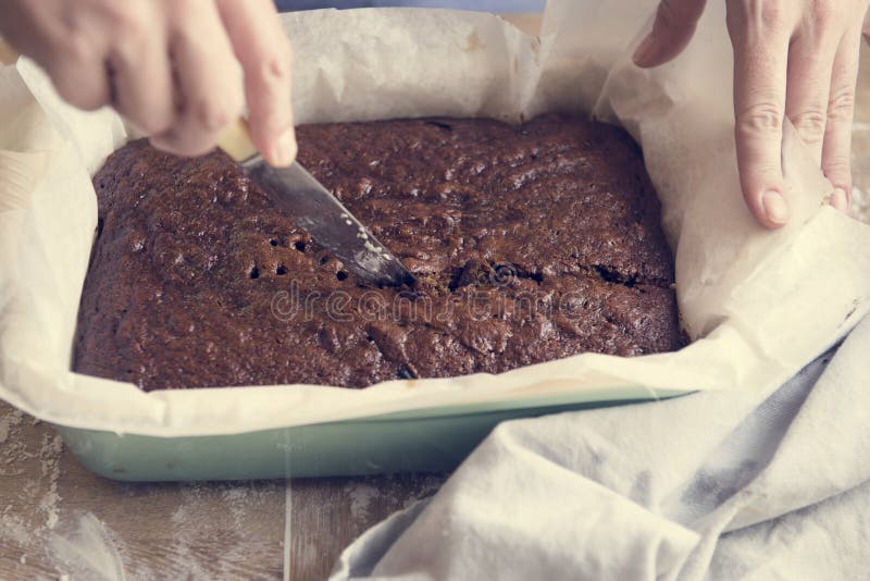 Bolo de queijo de brownie caseiro em chapa branca, decorado com morangos,  mirtilo e cereja, no jogo americano estilo inglês, na mesa de madeira.  usado para decorar a loja.