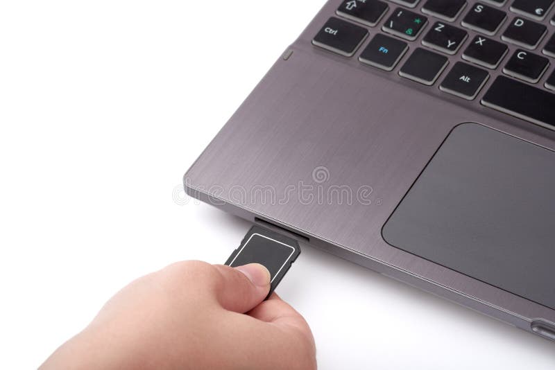 Ideia do close-up da mão da mulher com o cartão preto do SD Conecta a um leitor em um portátil com um teclado No fundo branco fotografia de stock royalty free Ideia do close-up da mão da mulher com o cartão preto do SD Conecta a um leitor em um portátil com um teclado No fundo branco fotografia de stock royalty free