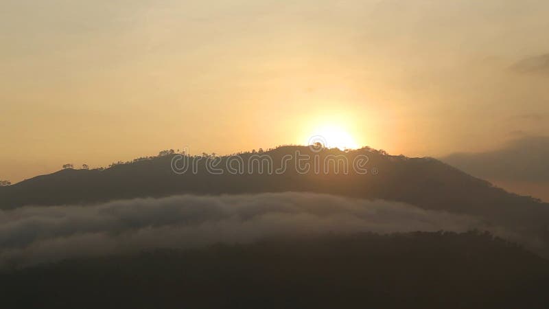 Ideia do nascer do sol nevoento no pico do Adam pequeno em Ella, Sri Lanka