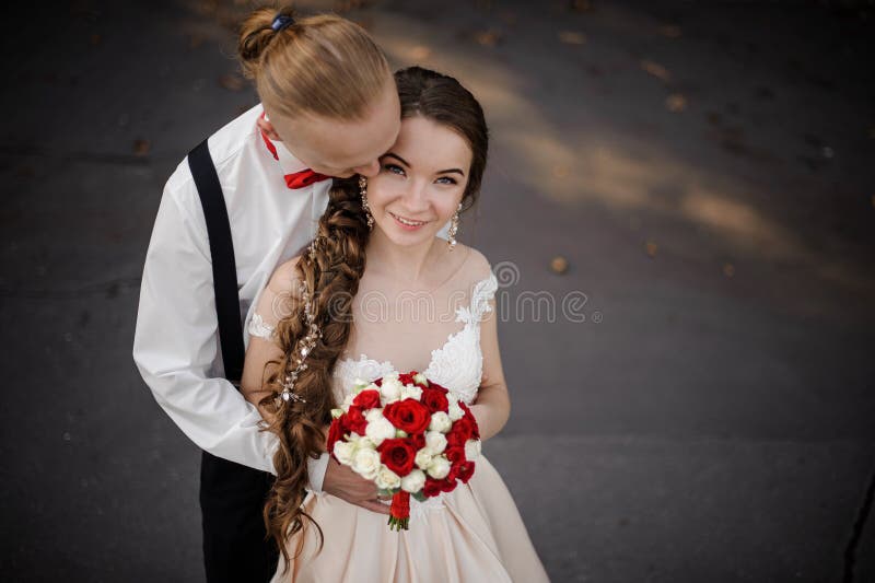 Ideia superior de um casal feliz novo com um ramalhete do casamento imagem de stock royalty free Ideia superior de um casal feliz novo com um ramalhete do casamento imagem de stock royalty free