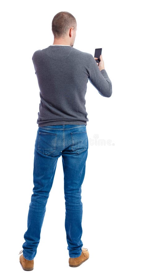 Ideia traseira de apontar os homens novos que falam no telefone celular fotos de stock royalty free Ideia traseira de apontar os homens novos que falam no telefone celular fotos de stock royalty free