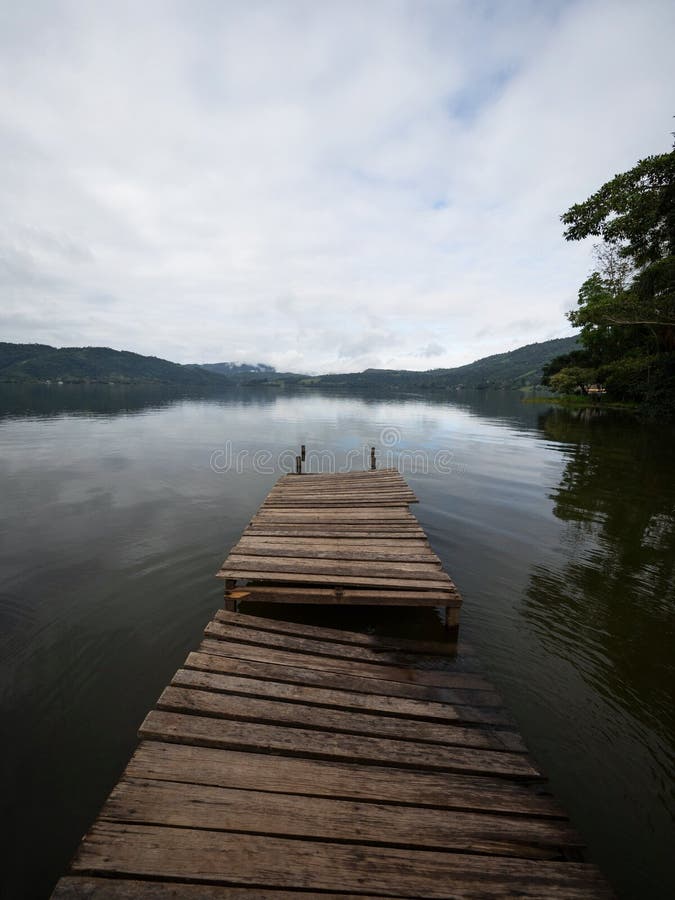 Idyllic Amazon rainforest jungle river lake landscape with broken damaged wooden jetty dock pier in Peru South America