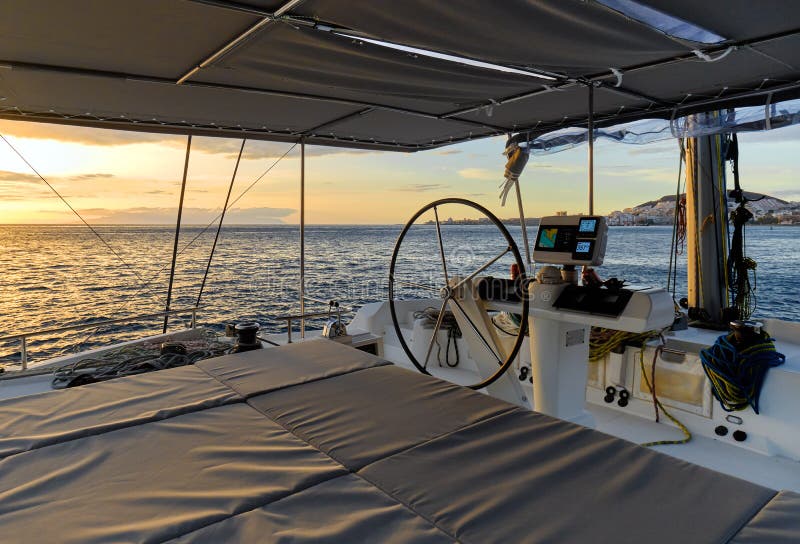 Idyllic scenery glowing sun down Ocean calm water view from catamaran flybridge open deck