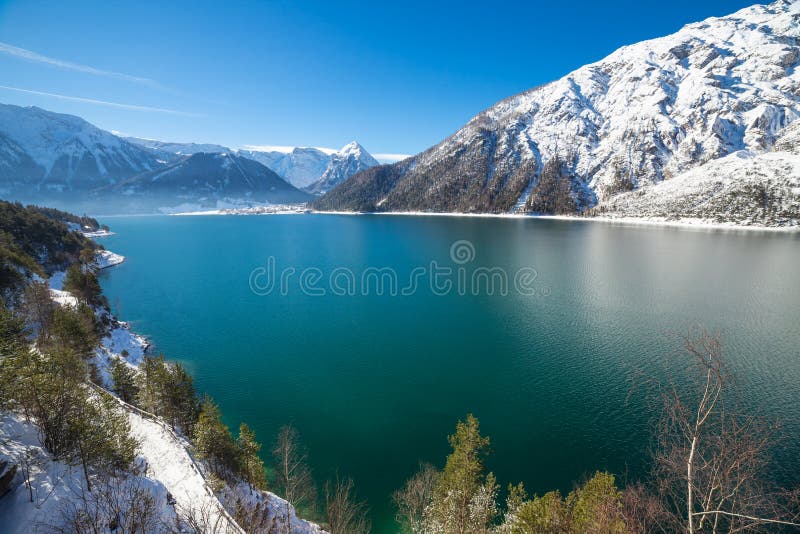 Idyllic snow landscape with mountain lake in the Alps