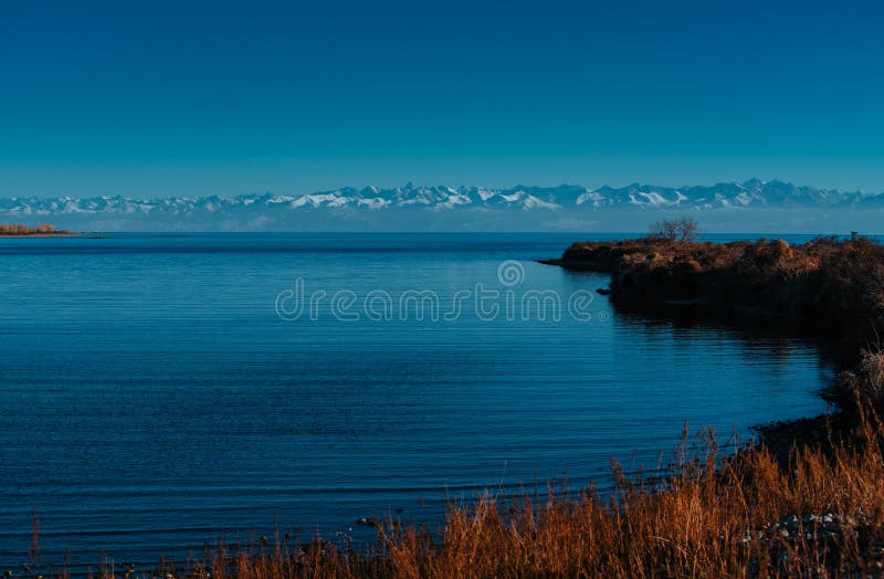 Idyllic view of lake on mountains background stock images