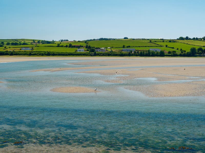 An idyllic view where green fields roll towards the water, perfect spot for contemplation royalty free stock photography