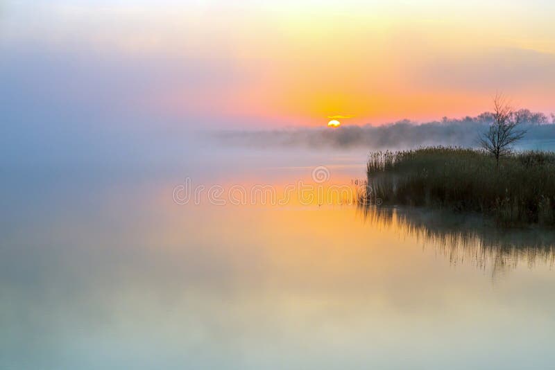 Idyllische Ansicht des Morgen-Nebels über See und aufgehende Sonne lizenzfreie stockbilder