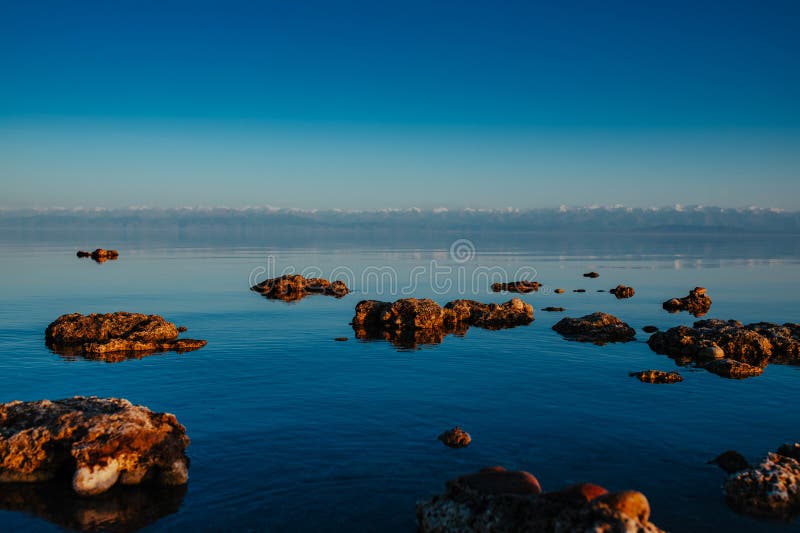 Idyllische Aussicht auf felsige See und Berge lizenzfreies stockbild