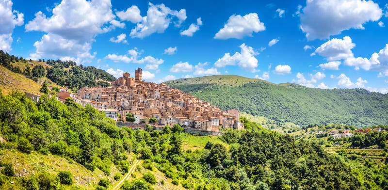 Beautiful view of idyllic village Castel del Monte, set into a steep hillside under apennine mountain peaks on a sunny summer day, Gran Sasso e Monti della Laga National Park, L'Aquila, Abruzzo, Italy. Beautiful view of idyllic village Castel del Monte, set into a steep hillside under apennine mountain peaks on a sunny summer day, Gran Sasso e Monti della Laga National Park, L'Aquila, Abruzzo, Italy