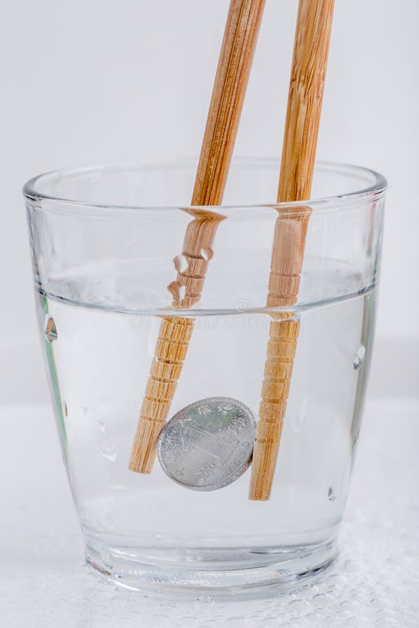 Ienes japoneses da moeda que guardam por hashis de madeira em um vidro de w
