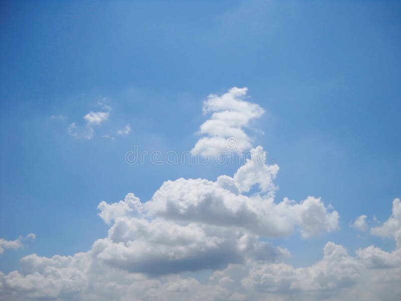 If cloud could be playful and zig zaging. Background of skyscape with various shapes of clouds over sky, during high humidity of air. In tones of blue, grey, white.
