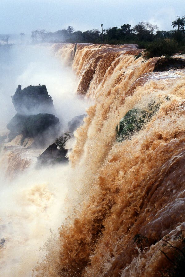 View of the Iguazu falls. Iguassu Falls is the largest series of waterfalls on the planet, located in Brazil, Argentina, and Paraguay. At some times during the year one can see as many as 275 separate waterfalls cascading along the edges of 2,700 meters (1.6 miles) cliffs. Argentines spells this wonder, Iguazu, the Brazilians, Igaucu. South America. View of the Iguazu falls. Iguassu Falls is the largest series of waterfalls on the planet, located in Brazil, Argentina, and Paraguay. At some times during the year one can see as many as 275 separate waterfalls cascading along the edges of 2,700 meters (1.6 miles) cliffs. Argentines spells this wonder, Iguazu, the Brazilians, Igaucu. South America