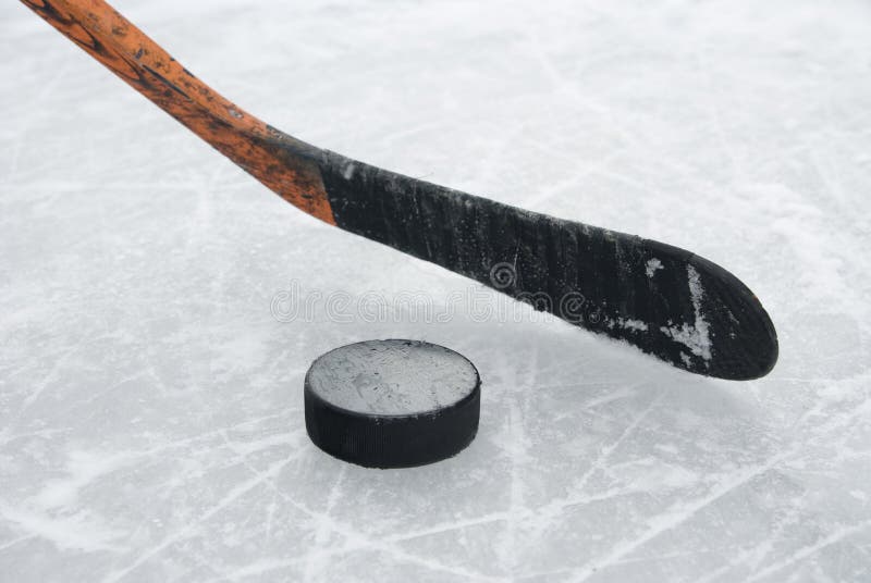 Ijshockey stok en puck op ijs