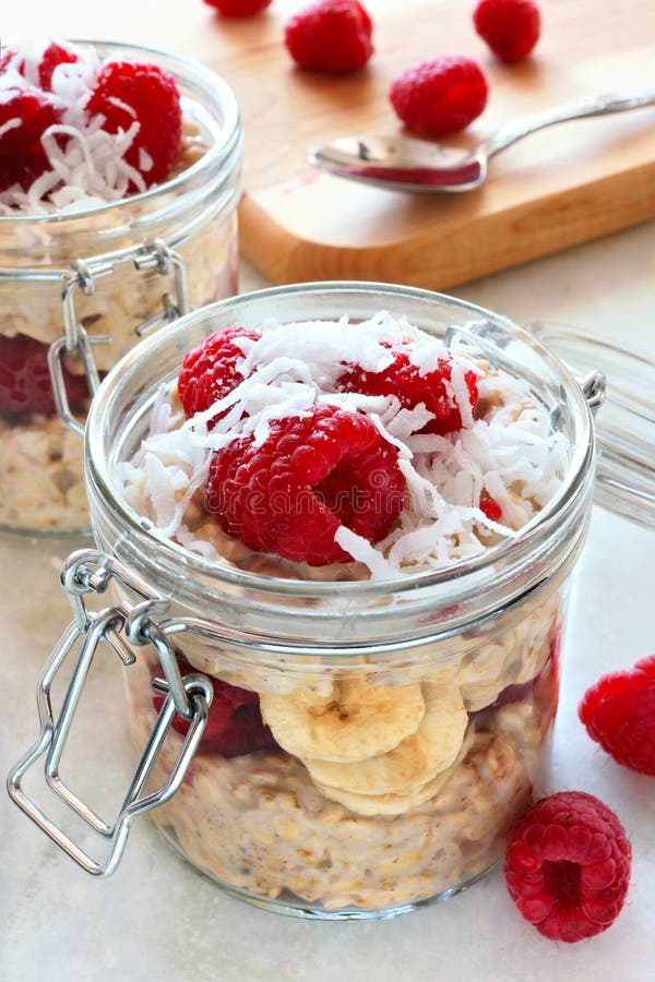 Healthy breakfast refrigerator oatmeal with fresh raspberries and shredded coconut in glass jars. Healthy breakfast refrigerator oatmeal with fresh raspberries and shredded coconut in glass jars