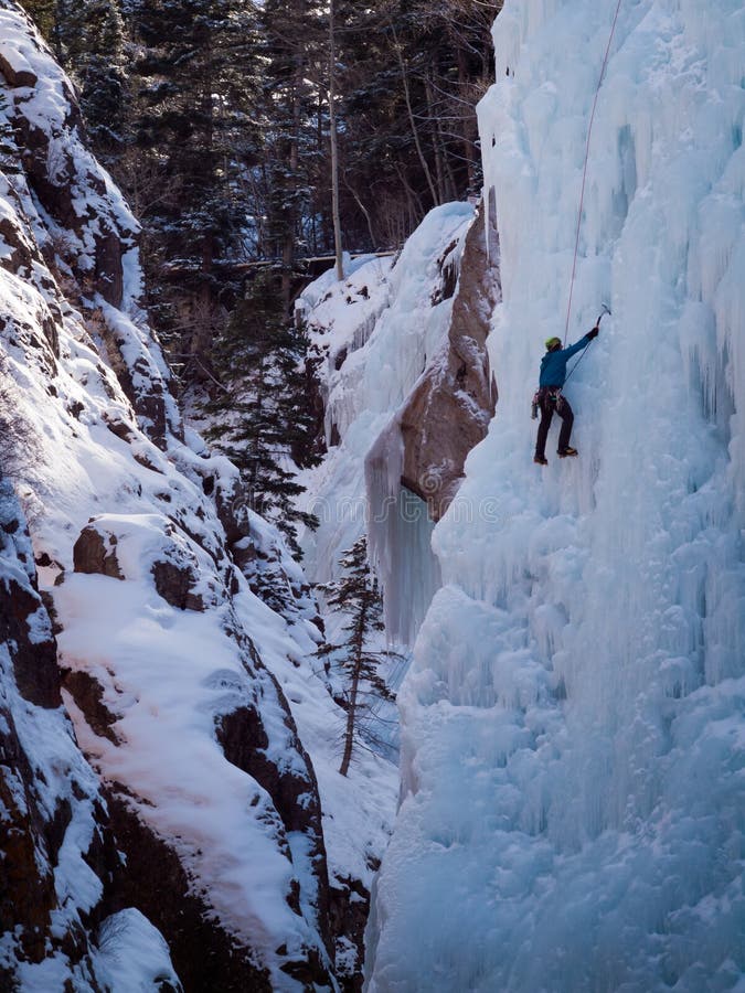 Alpinist ascenting a frozen waterfall in Ice park, Ouray. Alpinist ascenting a frozen waterfall in Ice park, Ouray.