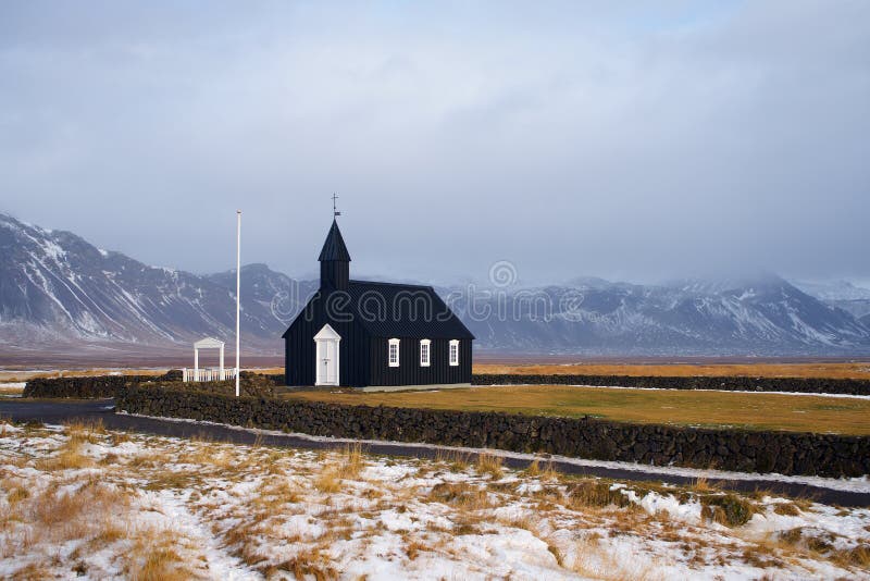 IJslandse zwarte kerk met bergen in de winter royalty-vrije stock foto's IJslandse zwarte kerk met bergen in de winter royalty-vrije stock foto's