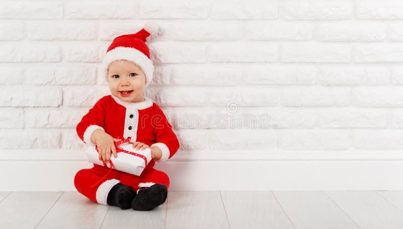 Il bambino felice in Natale costume Santa Claus con i regali immagine stock Il bambino felice in Natale costume Santa Claus con i regali immagine stock