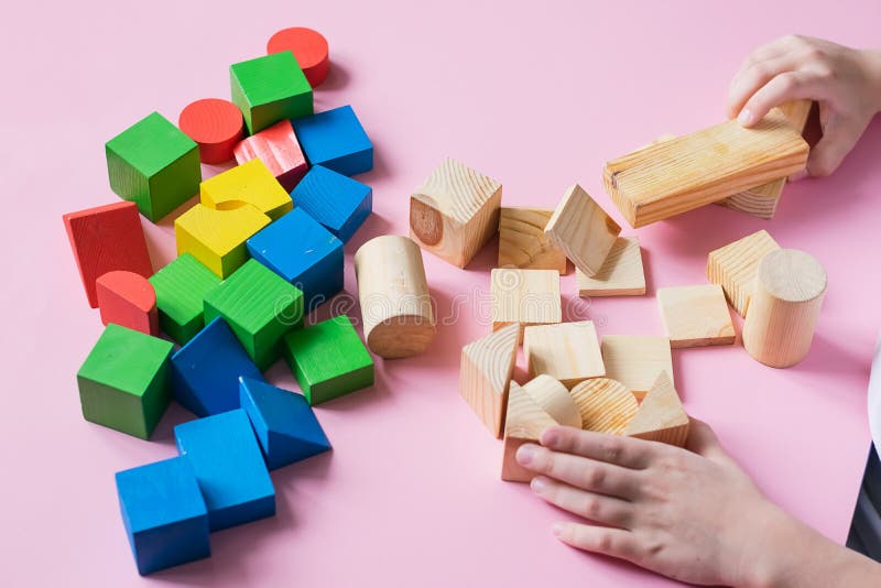 Il bambino gioca collezionando cubi di legno colorati. concetto educativo per l'apprendimento speciale dei bambini.