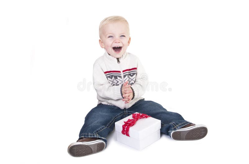 Il bambino ha eccitato circa l'apertura del suo presente nuovo immagine stock libera da diritti Il bambino ha eccitato circa l'apertura del suo presente nuovo immagine stock libera da diritti