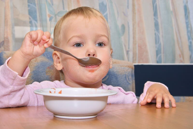 Il bambino mangia con il cucchiaio