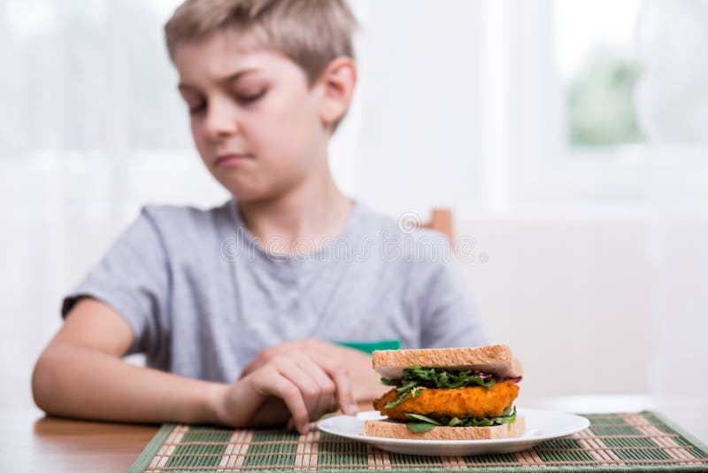 Il bambino non vuole il panino sano fotografia stock Il bambino non vuole il panino sano fotografia stock
