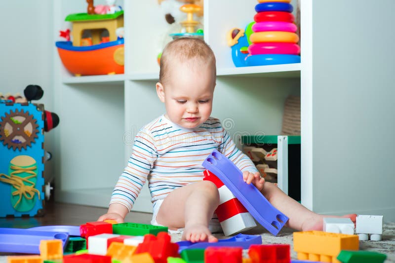 Il bambino riproduce un costruttore domestico colorato e lo spazio di copia. sviluppo di bambini dalla nascita immagine stock libera da diritti
