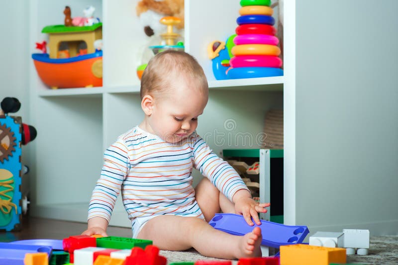 Il bambino riproduce un costruttore domestico colorato e lo spazio di copia. sviluppo di bambini dalla nascita fotografia stock