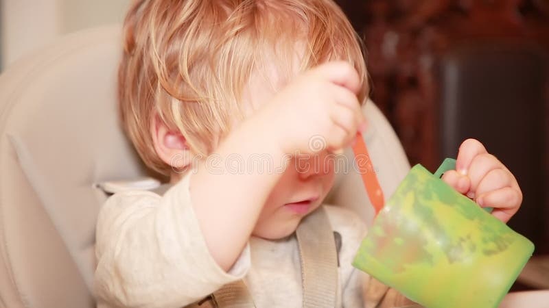 Il bambino stesso mangia il porridge con un cucchiaio piccolo