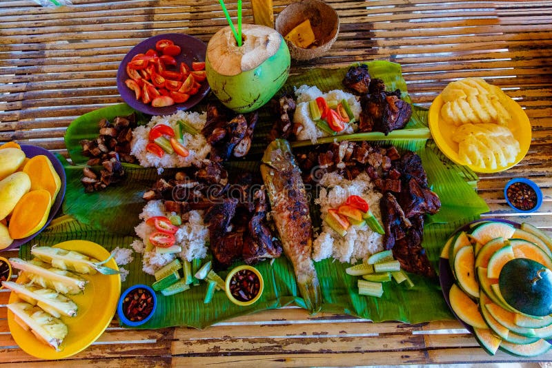 Il barbecue di pollo, maiale e pesce è servito su foglie di bambù con verdure e frutta Cucina filippina