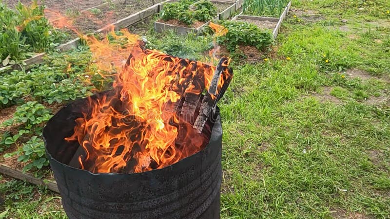 Inceneritore giardino bin bruciando scarti da giardino con il fumo  proveniente dalla canna fumaria Foto stock - Alamy