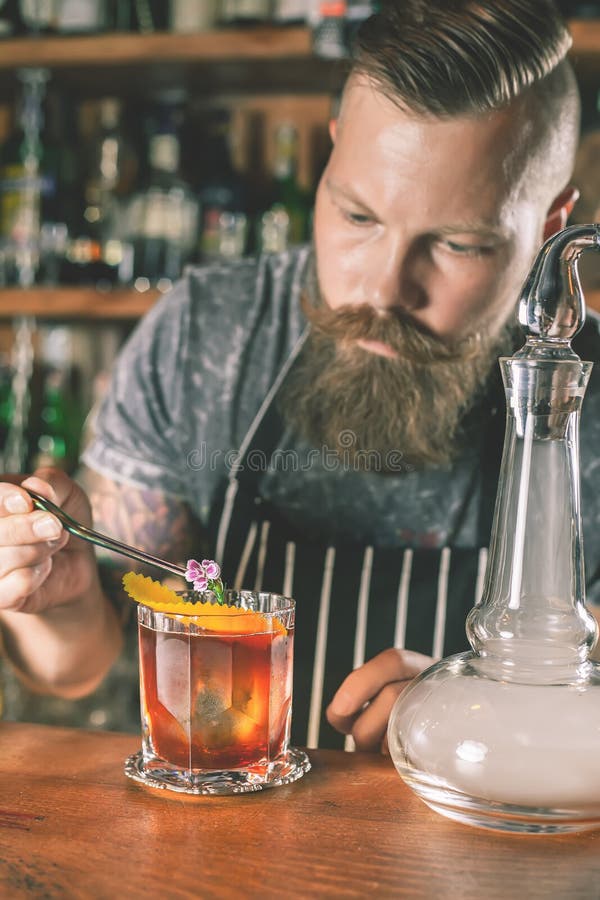 Il barista bello sta facendo il cocktail fotografia stock
