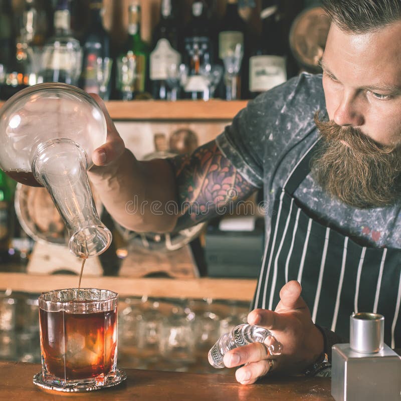 Un barista affascinante sta preparando un cocktail immagine stock