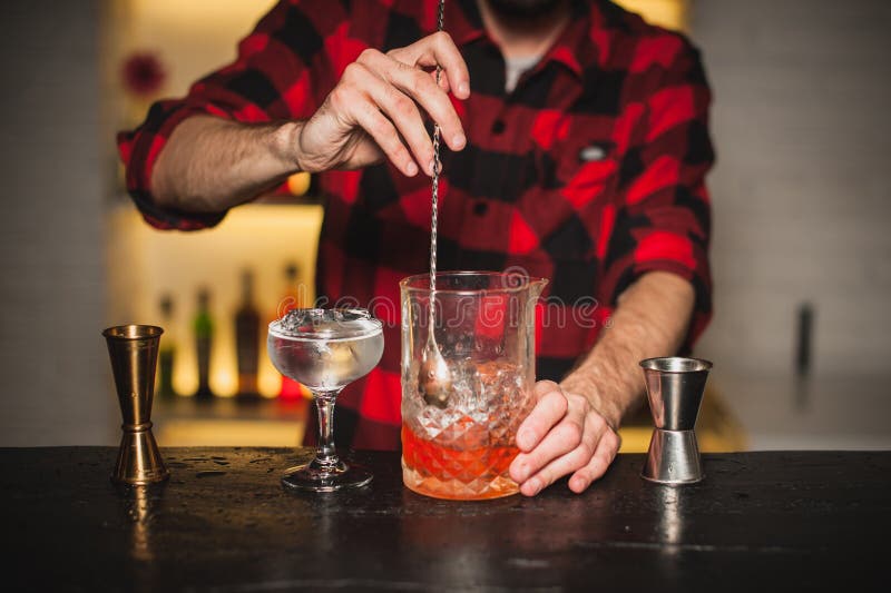 Il barista sta mescolando i cocktail sul contatore della barra fotografie stock libere da diritti Il barista sta mescolando i cocktail sul contatore della barra fotografie stock libere da diritti